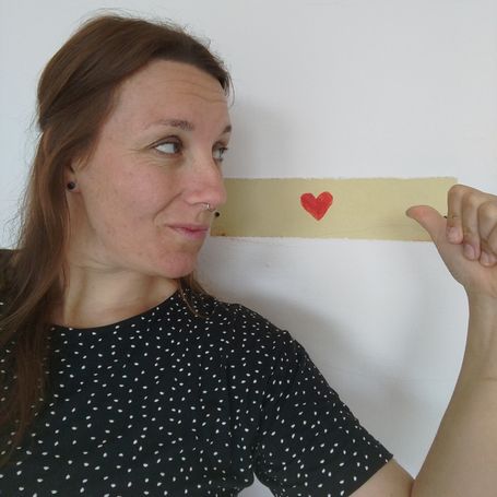 Susann blickt auf ein an die Wand gemaltes Herz.